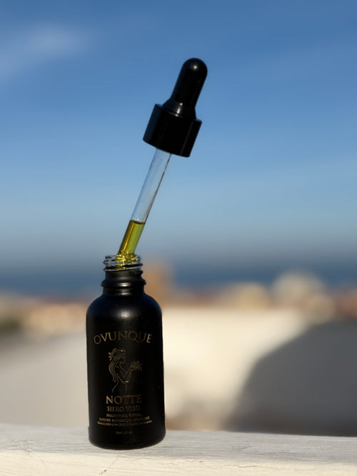 Black bottle with dropper labeled against a blurred natural background in Sarento, Amalfi Coast, Italy