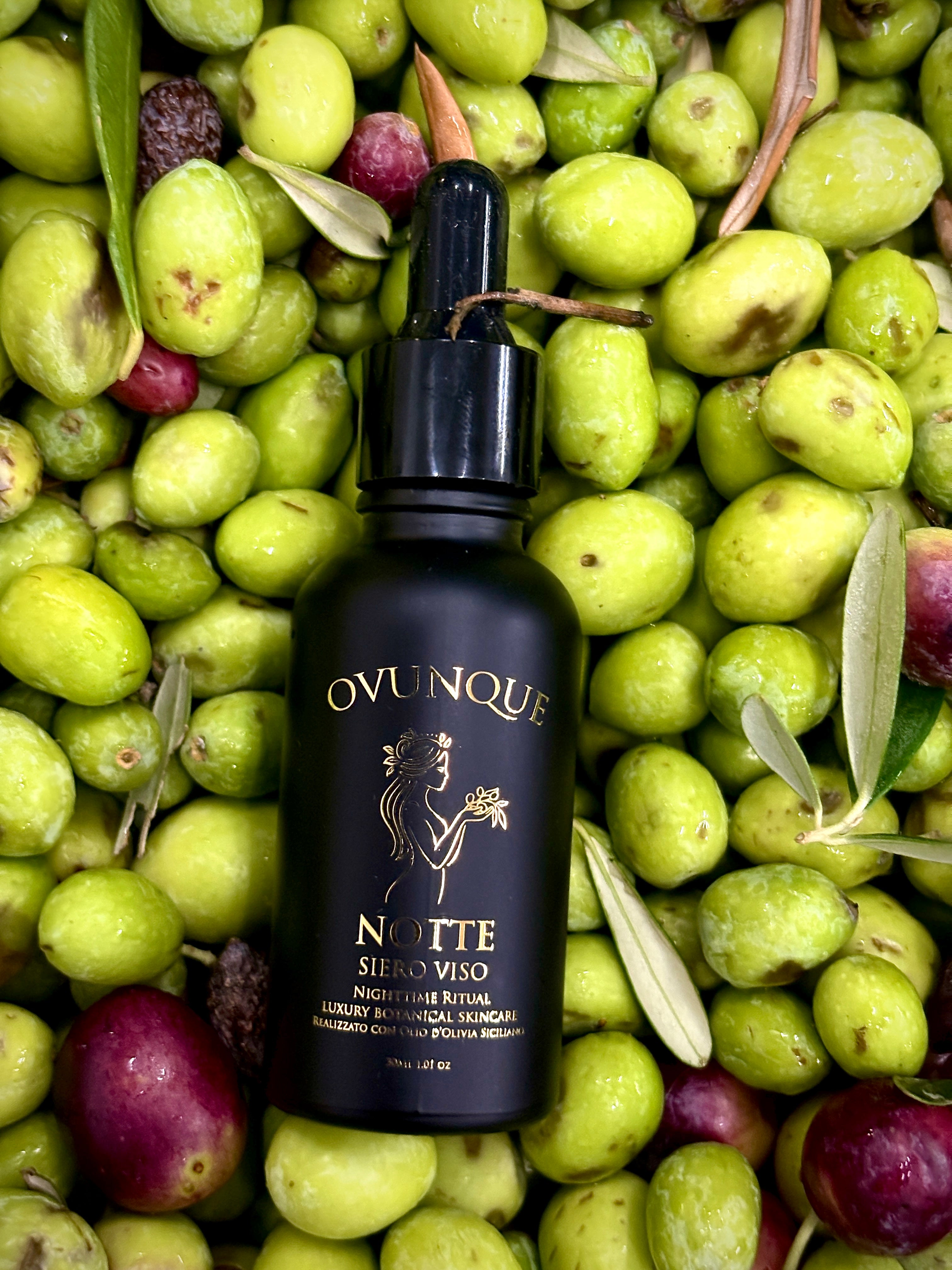 Notte bottle on a bed of freshly harvested green olives